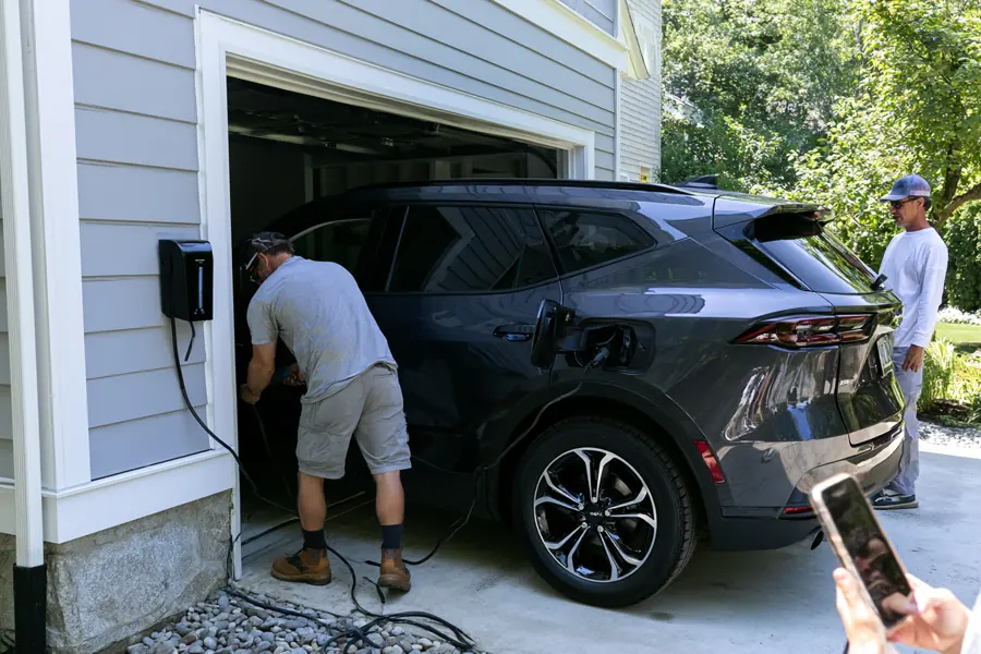 Electrician fitting a car charger to a garage wall