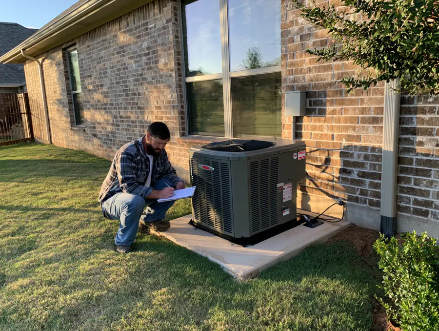 Standby generator on a concrete pad beside a brick house