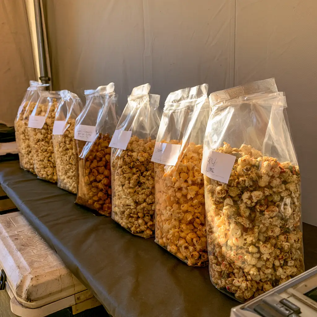 A row of tall labeled popcorn bags on a table